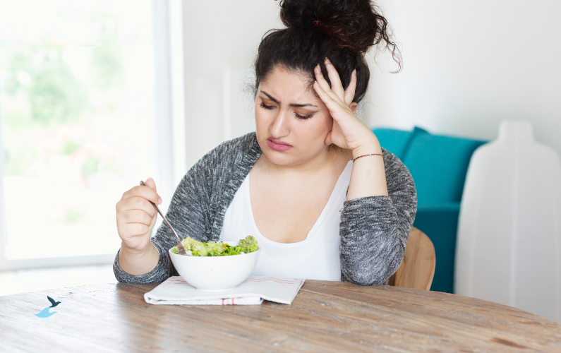Vrouw eet gefrustreerd een salade en probeert haar perfecte eetpatroon vol te houden